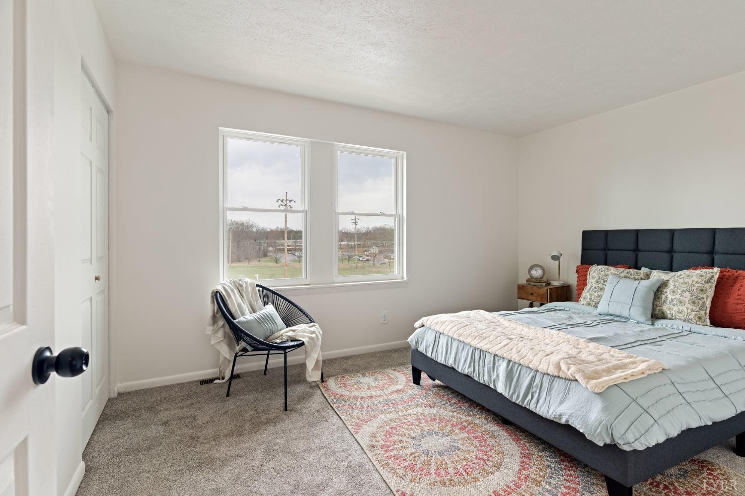 178 Dulwich Drive, Unit 200 Amherst, VA 24521 - Photo 12 of 22 a bedroom with a bed a chair and next to a window