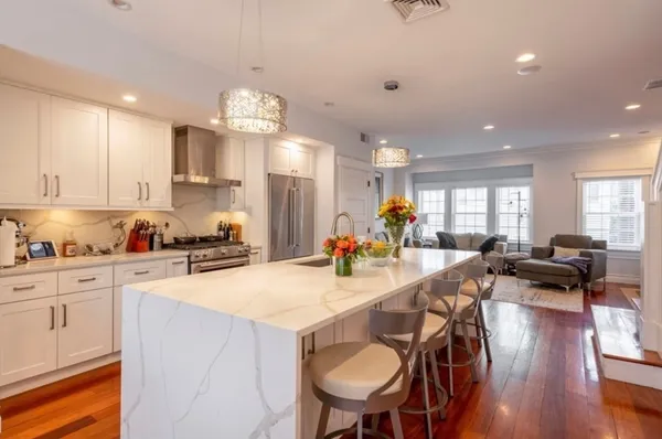 a view of a dining room and livingroom with furniture wooden floor a chandelier