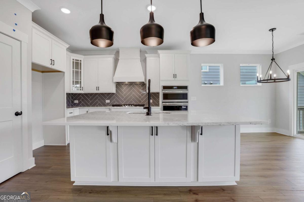 4250 Mary Ruth Way Loganville, GA 30052 - Photo 13 of 50 a kitchen with stainless steel appliances granite countertop a sink a microwave oven a refrigerator and white cabinets