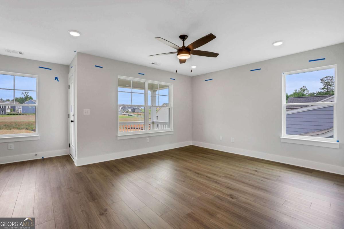4250 Mary Ruth Way Loganville, GA 30052 - Photo 23 of 50 a view of an empty room with wooden floor and a window