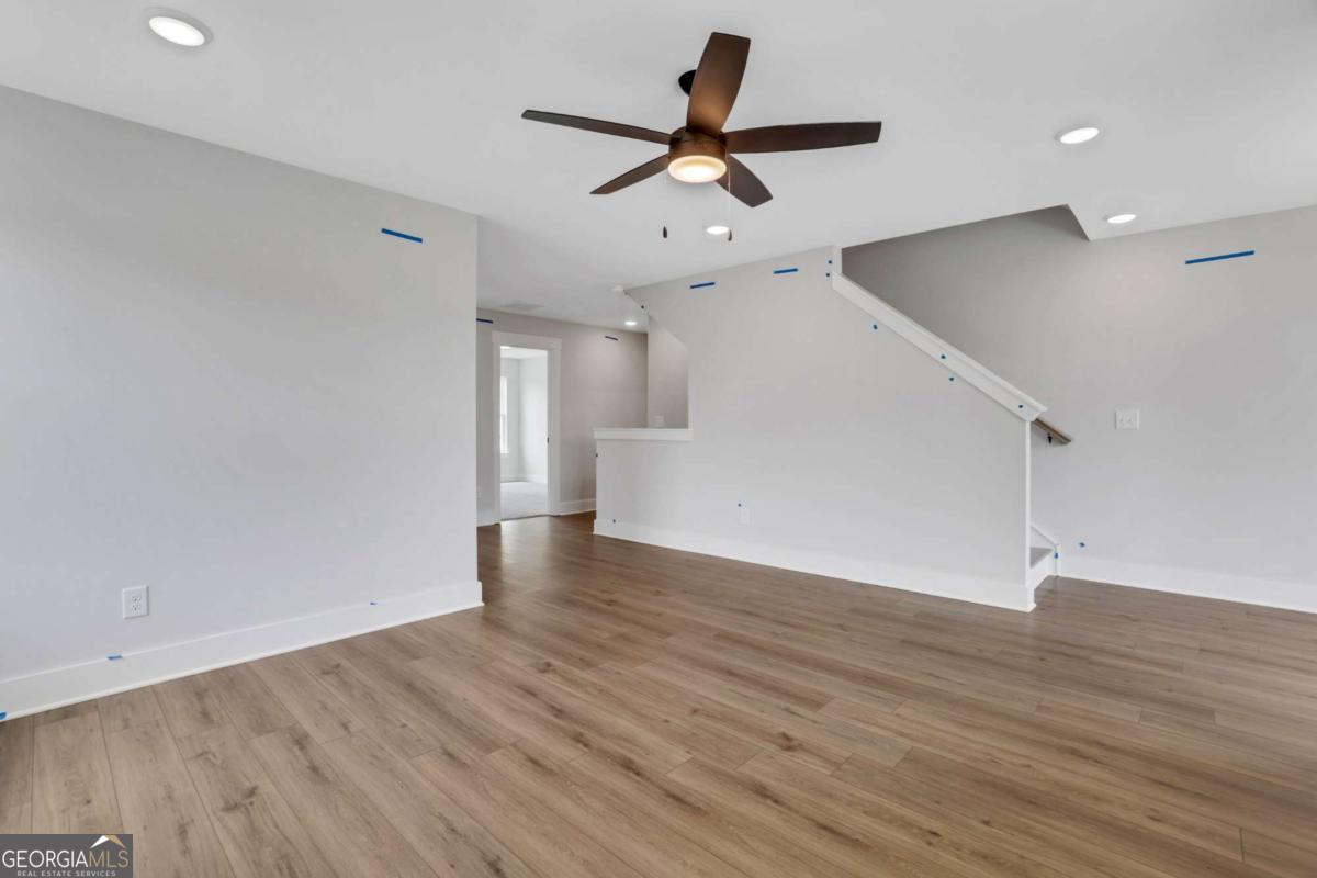 4250 Mary Ruth Way Loganville, GA 30052 - Photo 24 of 50 a view of an empty room with wooden floor and a ceiling fan