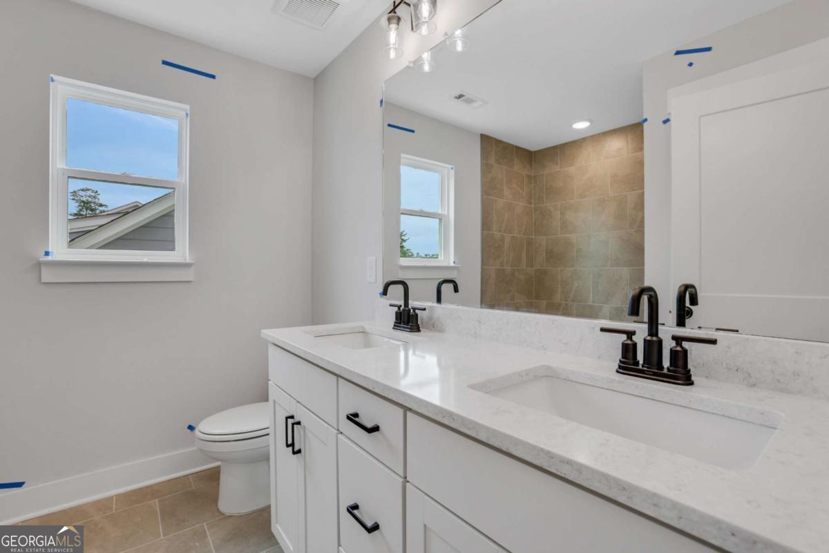 4250 Mary Ruth Way Loganville, GA 30052 - Photo 31 of 50 a bathroom with a sink a toilet and a mirror