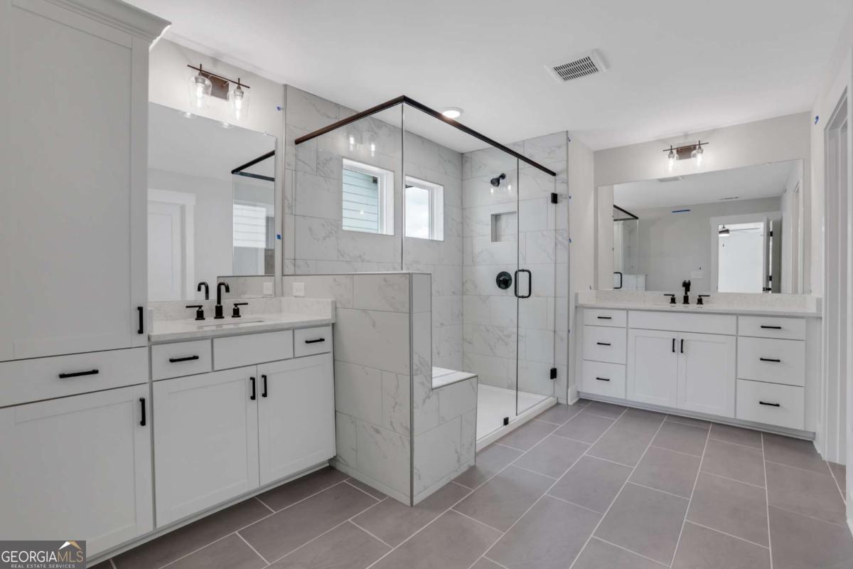 4250 Mary Ruth Way Loganville, GA 30052 - Photo 36 of 50 a spacious bathroom with a shower double sink and mirror