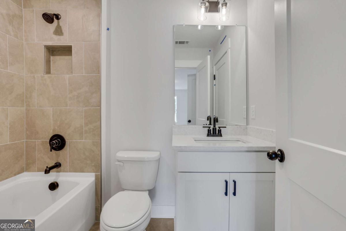 4250 Mary Ruth Way Loganville, GA 30052 - Photo 44 of 50 a bathroom with a sink a toilet and shower