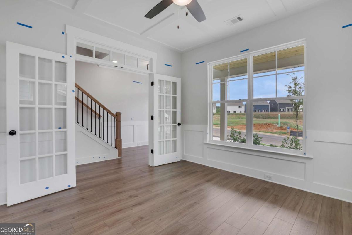 4250 Mary Ruth Way Loganville, GA 30052 - Photo 6 of 50 a view of an empty room with wooden floor and a window