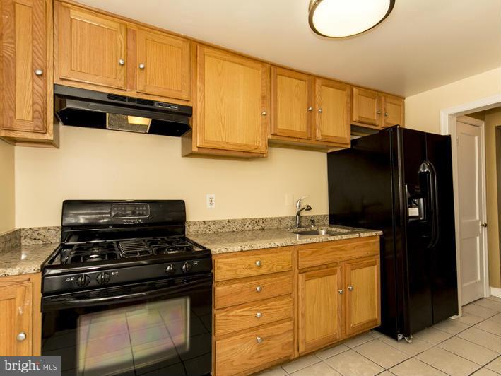 5115 Sunset Road Baltimore, MD 21215 - Photo 11 of 24 a kitchen with stainless steel appliances granite countertop a stove and a refrigerator with cabinets