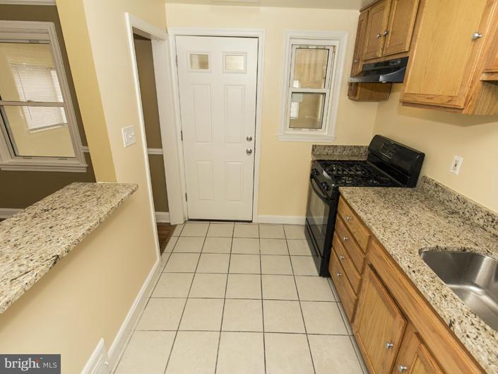 5115 Sunset Road Baltimore, MD 21215 - Photo 15 of 24 a kitchen with a stove a sink and a refrigerator