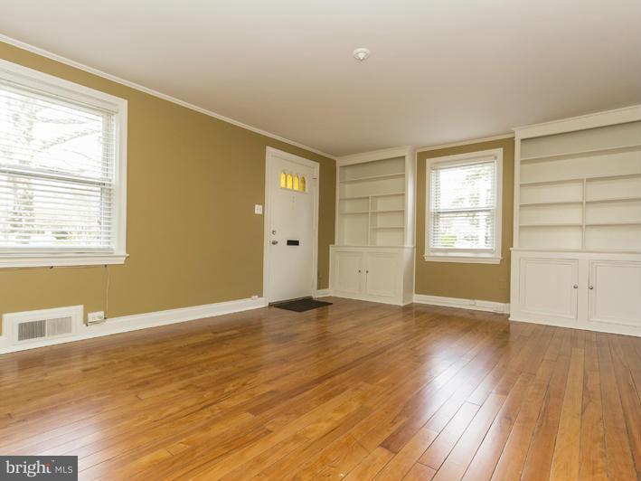 5115 Sunset Road Baltimore, MD 21215 - Photo 6 of 24 an empty room with wooden floor and windows