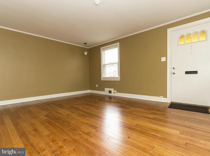 5115 Sunset Road Baltimore, MD 21215 - Photo 7 of 24 an empty room with wooden floor and windows