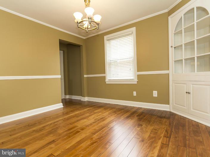5115 Sunset Road Baltimore, MD 21215 - Photo 10 of 24 an empty room with wooden floor and windows