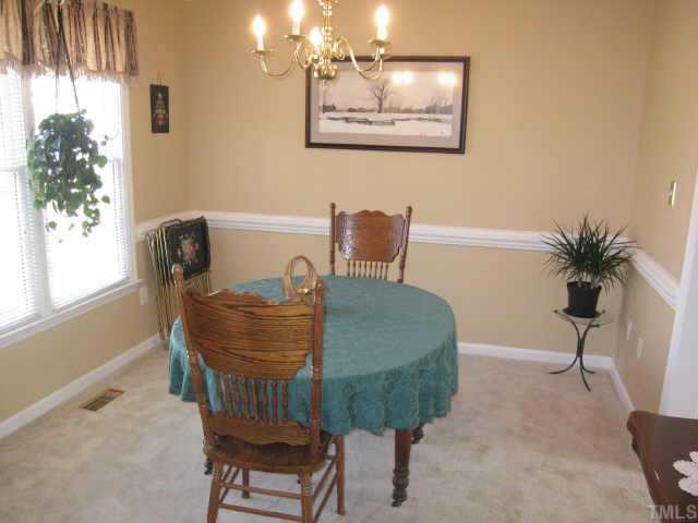 5108 Antler Ridge Court Raleigh, NC 27616 - Photo 3 of 10 a view of a dining room with furniture and a potted plant