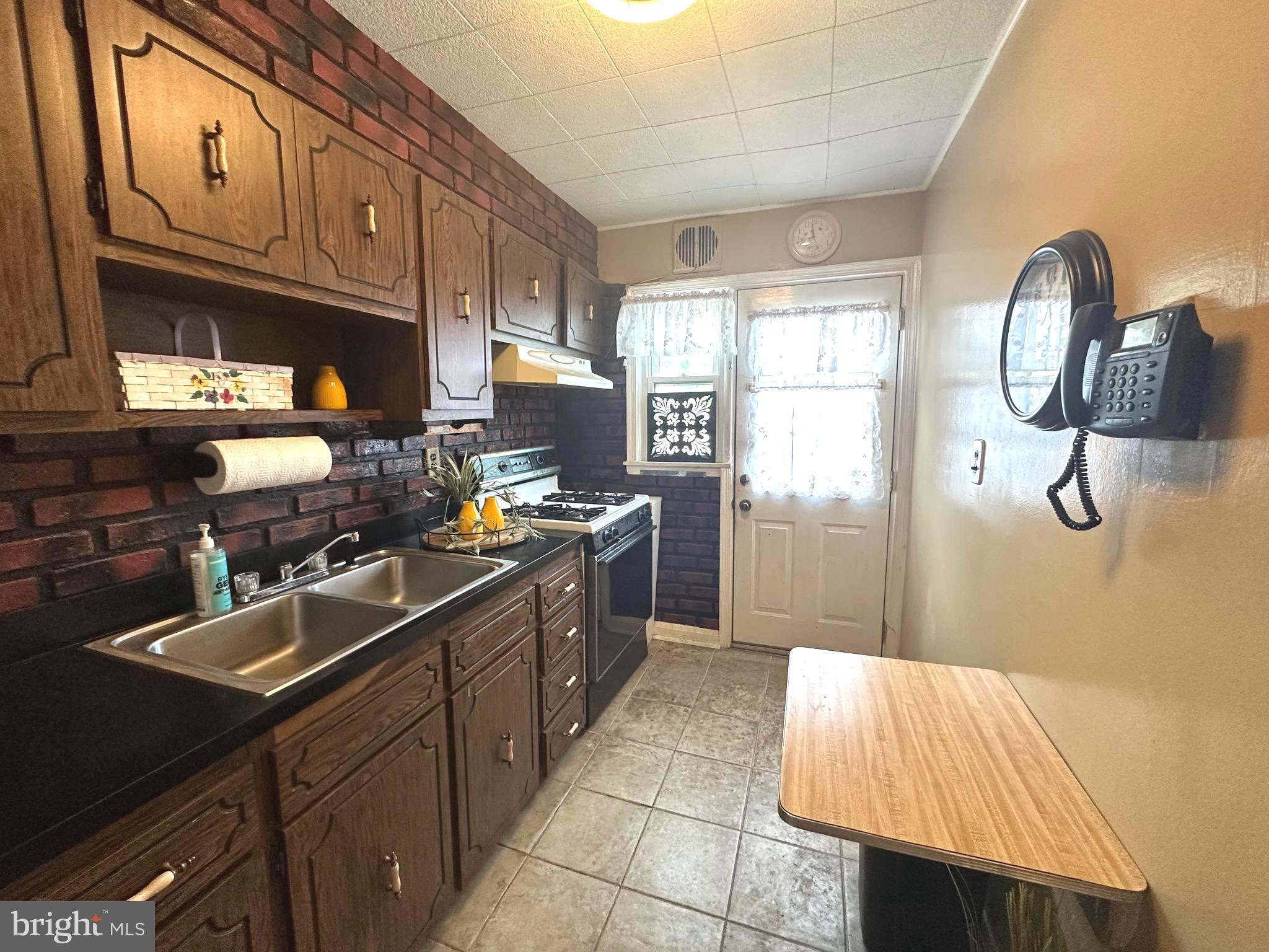 8454 Kavanagh Road Baltimore, MD 21222 - Photo 12 of 23 a kitchen with a sink dishwasher refrigerator stove and cabinets
