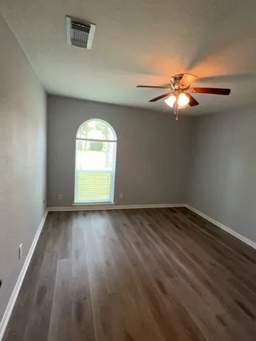 wooden floor in an empty room with a window