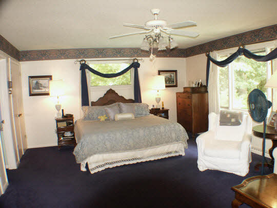4007 Landstrom Road Rockford, IL 61107 - Photo 4 of 7 a bedroom with a bed window and a chandelier