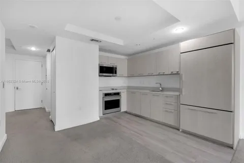 a kitchen with white cabinets and white appliances