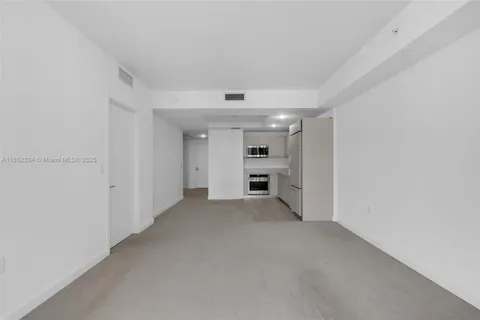 a view of empty room with refrigerator