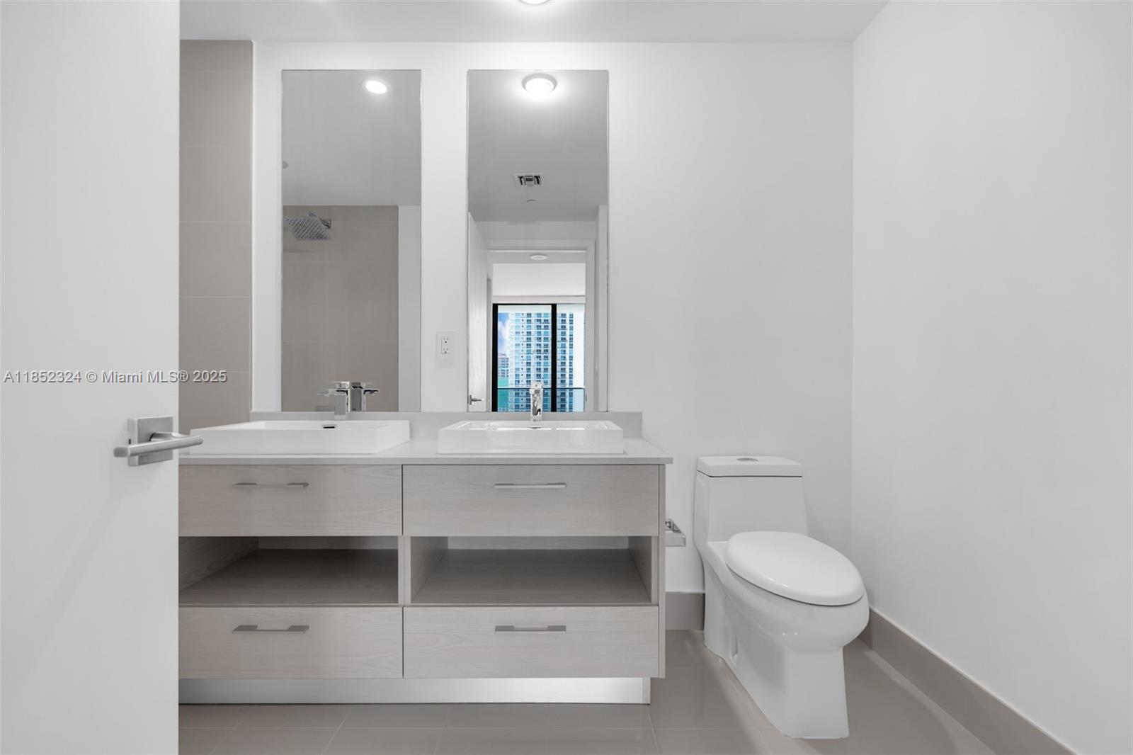 45 Southwest 9th Street, Unit 2204 Miami, FL 33130 - Photo 20 of 39 a bathroom with a sink vanity mirror and toilet