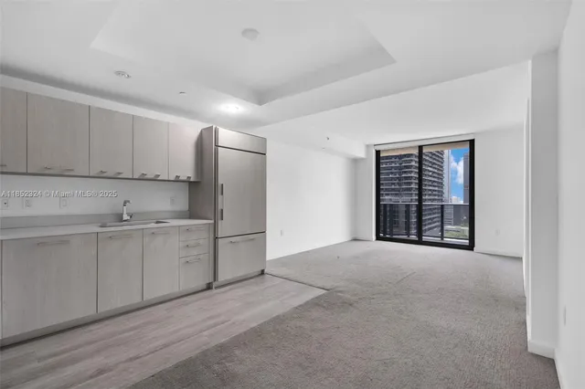 a view of an empty room with window and cabinet