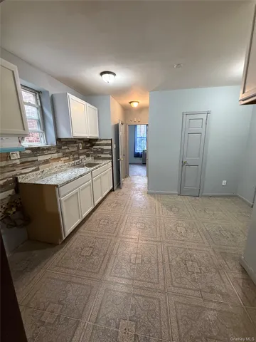 a large kitchen with granite countertop a stove and cabinets