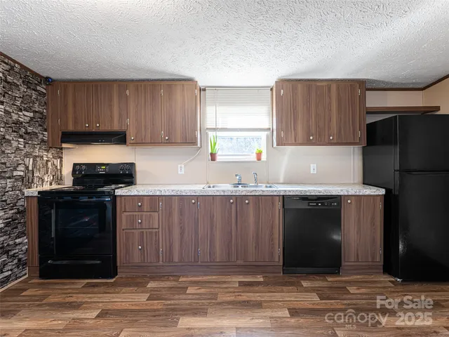 a kitchen with granite countertop a refrigerator stove and oven