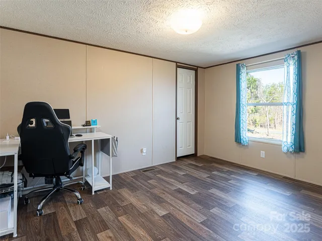 a view of a workspace with furniture and a window