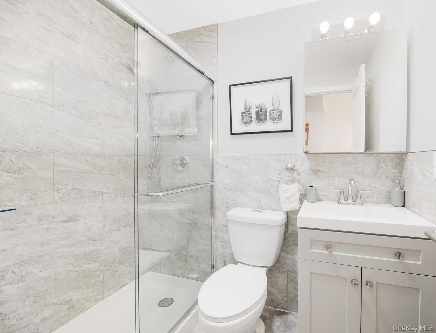 248 Rockne Road Yonkers, NY 10701 - Photo 15 of 40 Bathroom with vanity, a shower stall, and tile walls