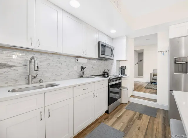 a kitchen with granite countertop white cabinets and white appliances