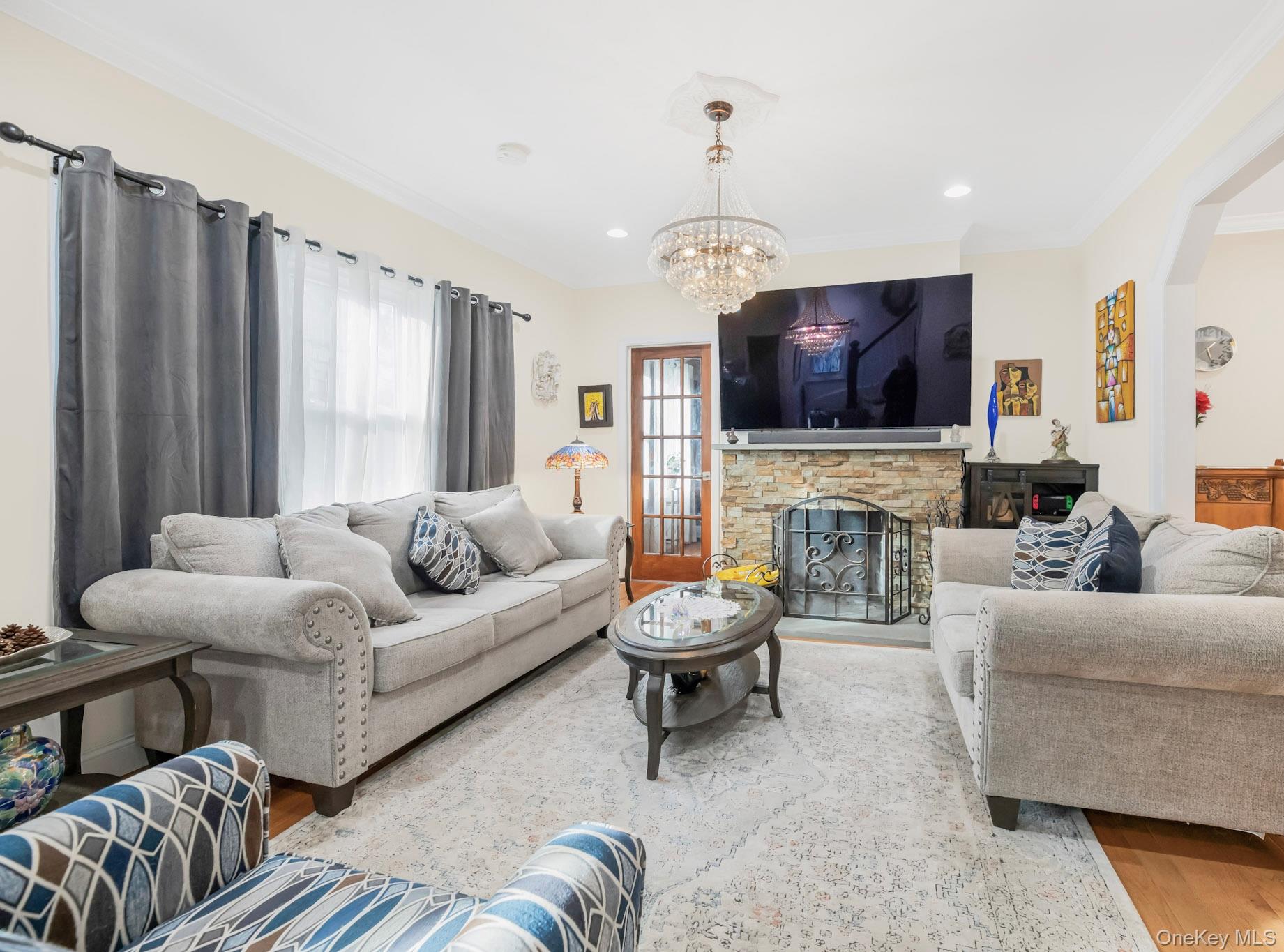 248 Rockne Road Yonkers, NY 10701 - Photo 21 of 40 Living room with wood finished floors, a fireplace, crown molding, a chandelier, and recessed lighting