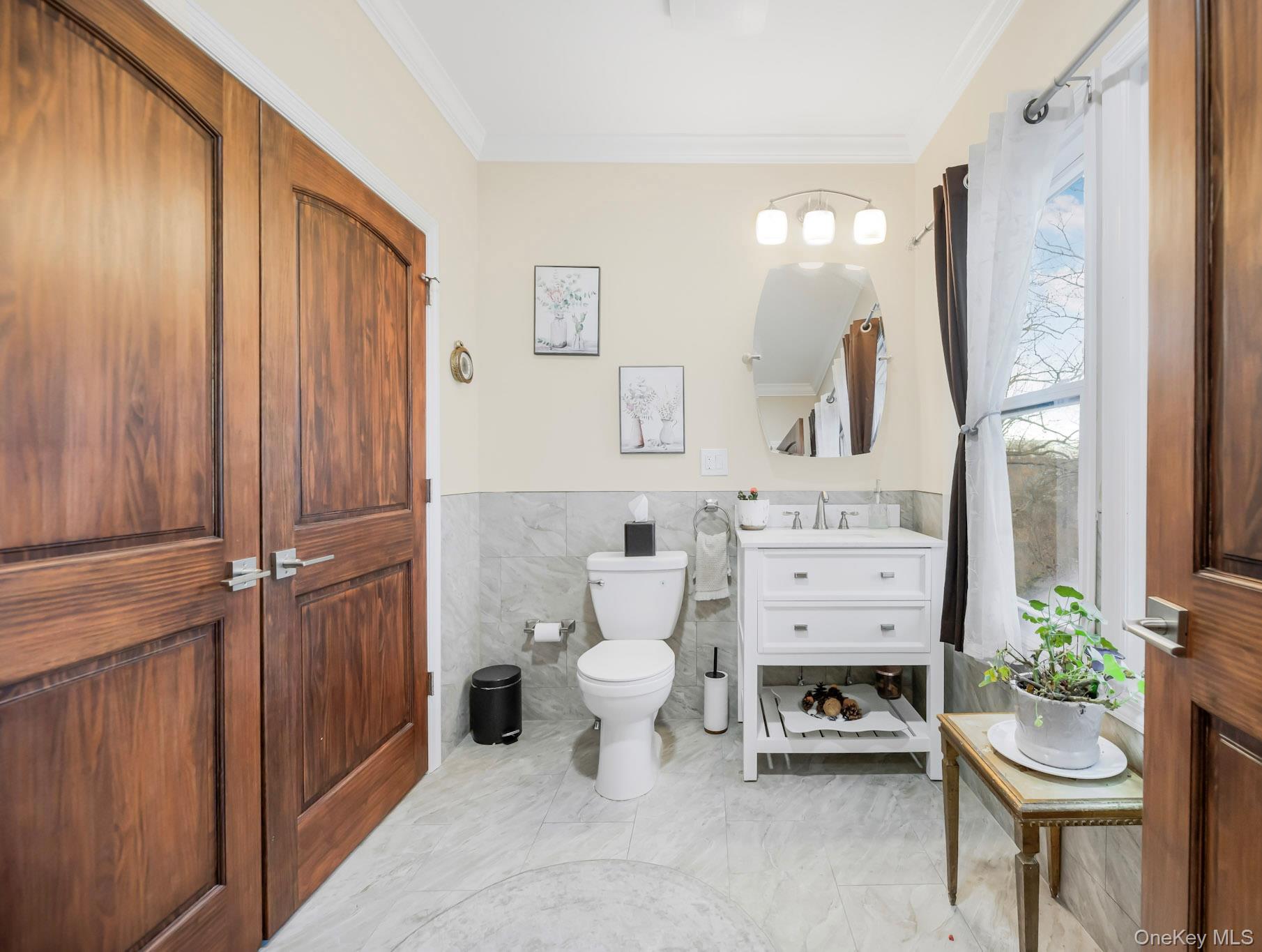 248 Rockne Road Yonkers, NY 10701 - Photo 24 of 40 Bathroom with tile walls, wainscoting, crown molding, vanity, and light marble finish floors