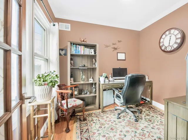 a view of a workspace with furniture and a window