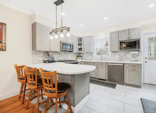 a kitchen with kitchen island a white counter top space appliances and cabinets