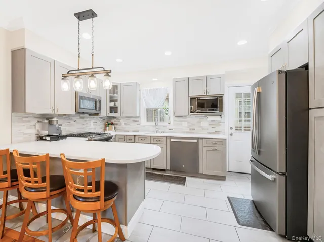 a large kitchen with kitchen island granite countertop a sink cabinets and stainless steel appliances