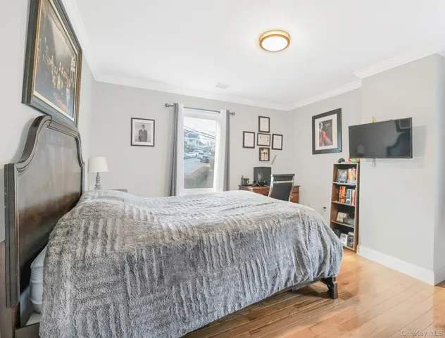 a bedroom with a large bed and a flat tv screen