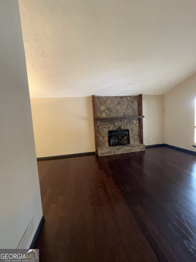 1265 Herrington Road Lawrenceville, GA 30044 - Photo 5 of 52 an empty room with wooden floor and fireplace