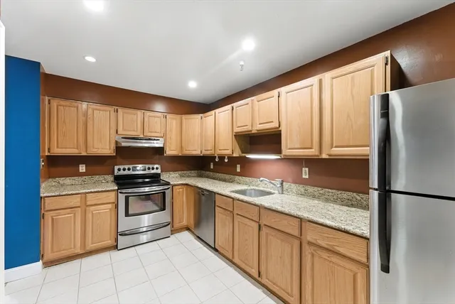 a kitchen with a sink a counter top space cabinets and stainless steel appliances