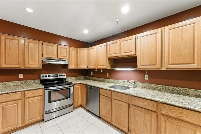 a kitchen with stainless steel appliances granite countertop a sink stove and cabinets