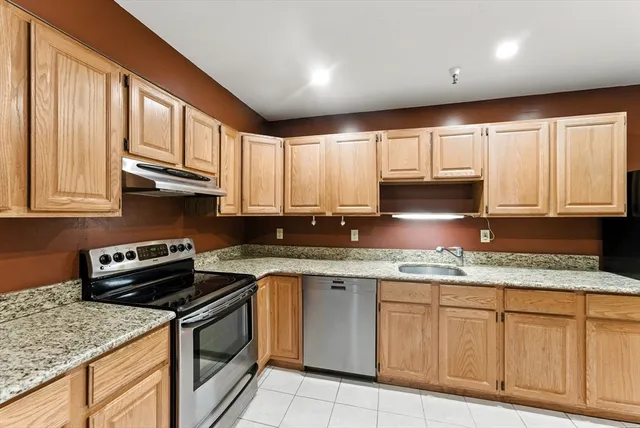 a large kitchen with stainless steel appliances granite countertop a stove a sink and a microwave
