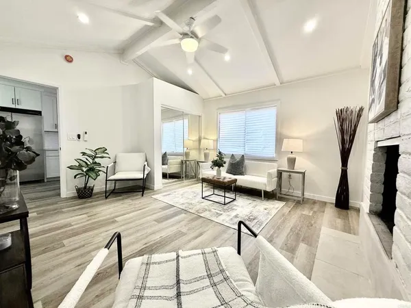 a kitchen with stainless steel appliances granite countertop a stove a sink dishwasher a dining table and chairs with wooden floor