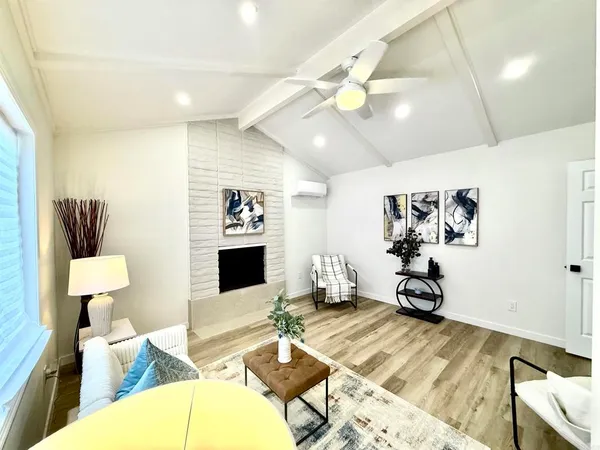 a living room with furniture a flat screen tv and a table