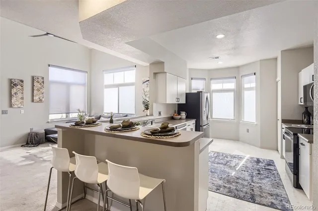 a kitchen with stainless steel appliances granite countertop a table and chairs in it