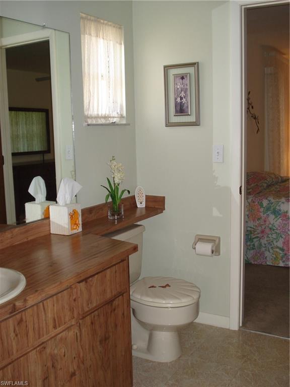 18057 Laurel Valley Road Fort Myers, FL 33967 - Photo 15 of 25 a bathroom with a toilet a sink and mirror