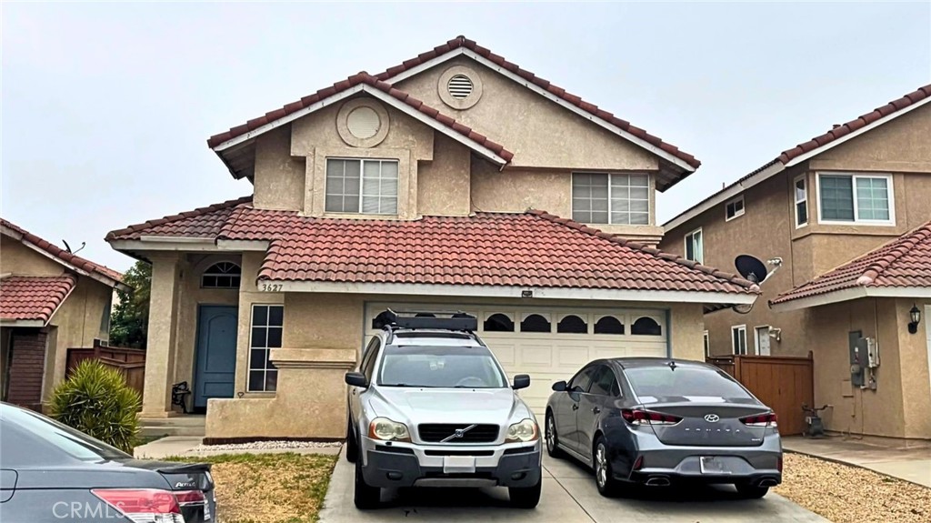 3627 Windstorm Way Riverside, CA 92503 - Photo 1 of 1 a car parked in front of a white house