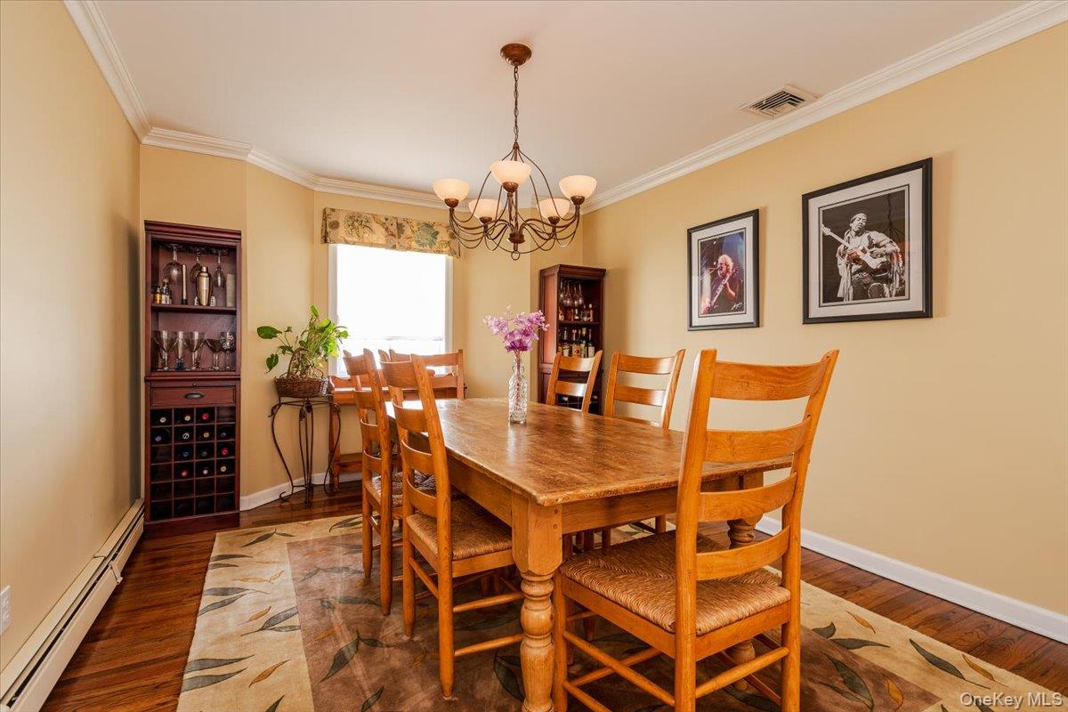 40 East Penn Street Long Beach, NY 11561 - Photo 12 of 41 a dining room with wooden floor a chandelier a wooden table and chairs