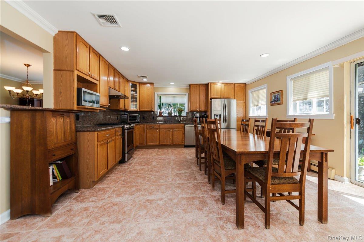 40 East Penn Street Long Beach, NY 11561 - Photo 14 of 41 a open kitchen with stainless steel appliances granite countertop a stove top oven a sink a dining table and chairs