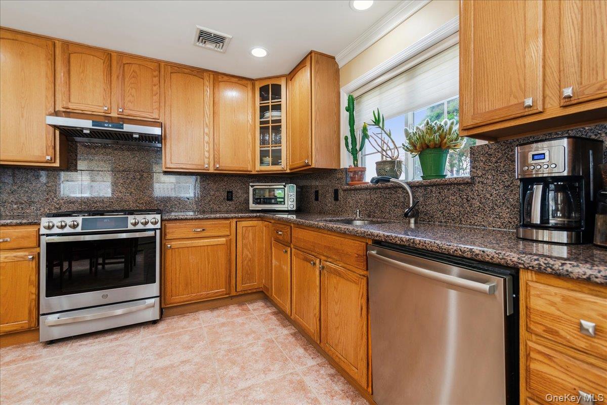 40 East Penn Street Long Beach, NY 11561 - Photo 16 of 41 a kitchen with stainless steel appliances granite countertop a stove sink and cabinets