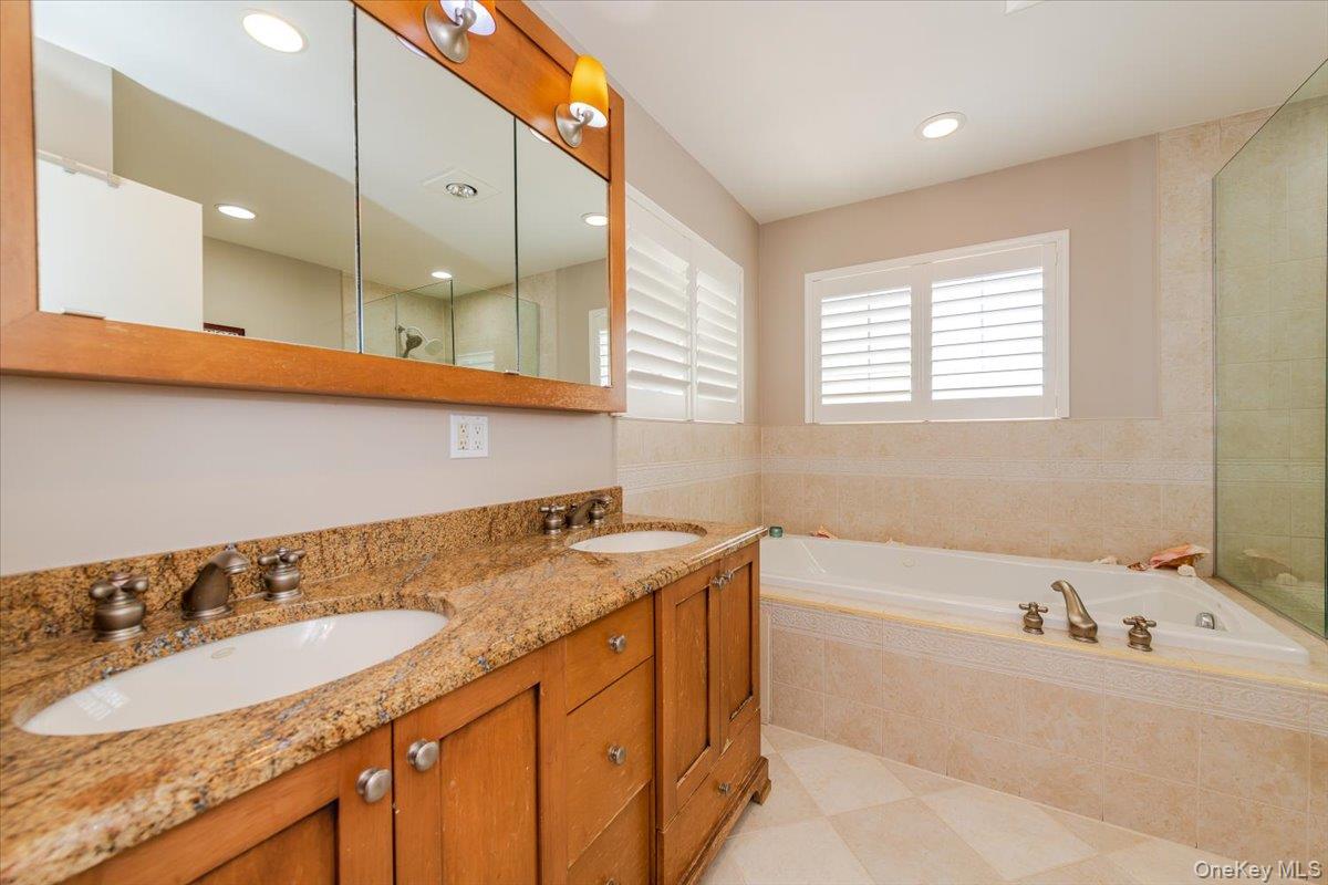 40 East Penn Street Long Beach, NY 11561 - Photo 20 of 41 a bathroom with a granite countertop sink and a bathtub