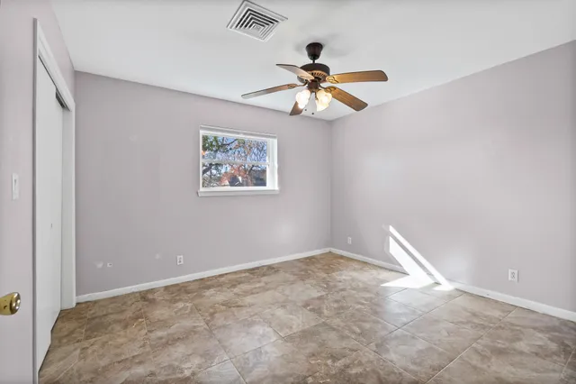 a view of a big room with wooden floor and ceiling fan