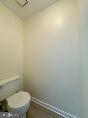 a white toilet sitting next to a white wall