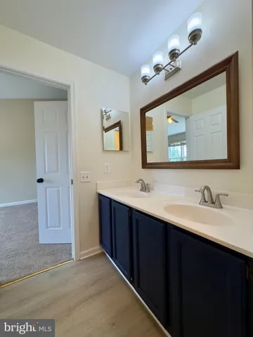 a bathroom with a double vanity sink and a mirror