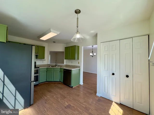 a kitchen with kitchen island white cabinets and stainless steel appliances